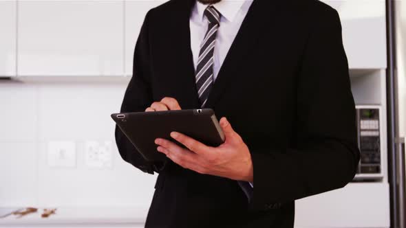 Businessman using digital tablet in kitchen