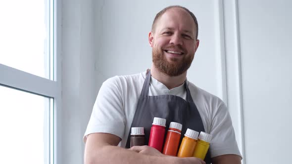 Smiling Stylish Artist Holding a Palette of Paints for Painting