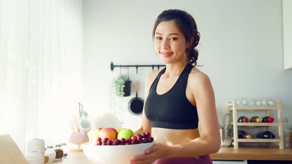 Portrait of Asian attractive woman hold fruit bowl and look at camera.