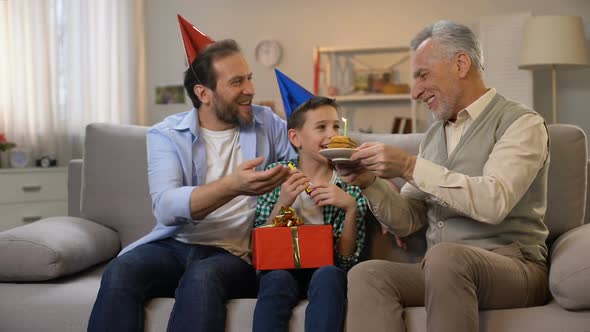 Middle-Aged Male and Preteen Boy Congratulating Grandpa With Anniversary, Family