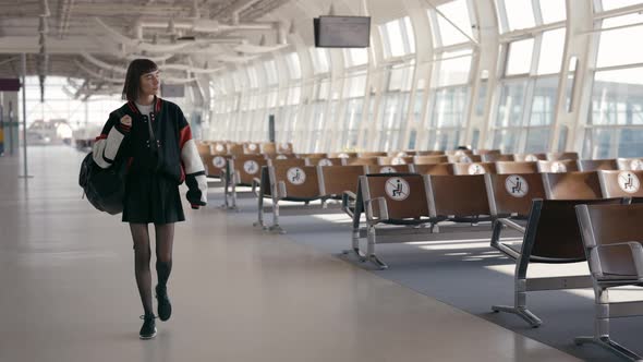 Stylish Woman with Short Haircut Walking at Empty Airport