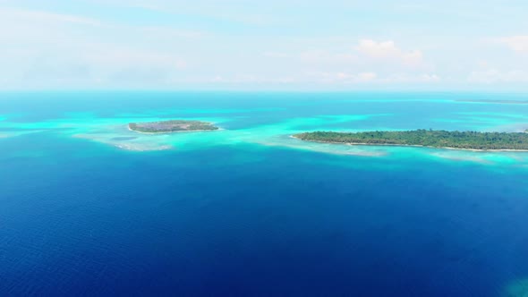 Aerial: flying over coral reef tropical caribbean sea turquoise blue water. Indo