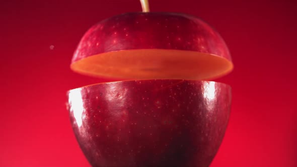 Half Red Apple Falling and Splashing on Fuchsia Red Background