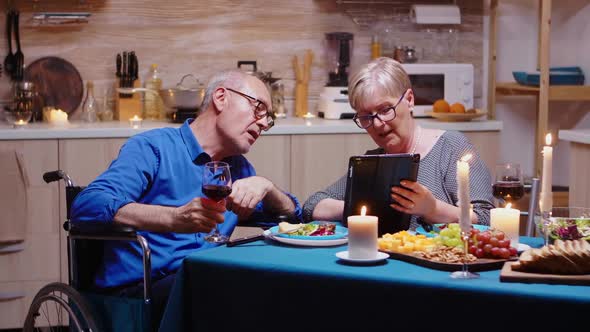 Woman and Immobilized Man Browsing on Tablet