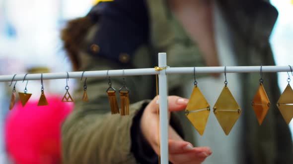 Woman selecting earrings from display