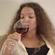 Peaceful Young Woman Drinks Red Wine From Large Wineglass - VideoHive Item for Sale