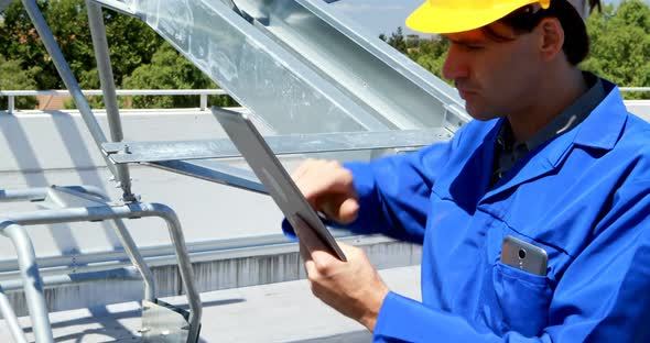 Male worker using digital tablet at solar station