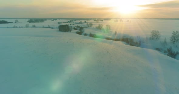 Aerial View of Cold Arctic Field Landscape Trees with Frost Snow Ice River and Sun Rays Over Horizon