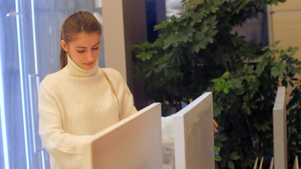 Lady in White Pullover Looks at Various Coloured Countertops