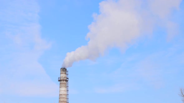 Industrial Smoke Stacks on Cityscape Background in Winter