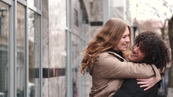 Passionate Young Couple Kissing And Embracing Spinning Around Outdoor In The City