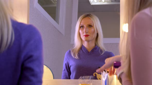 Young Girl Woman Looks at Herself in Small Mirror in Dressing Room