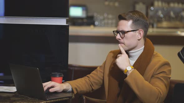 Confident Businessman Sit Thinking About Business Deals and Plans Using Laptop in Hotel Lobby Hall