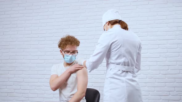 Young Nurse Giving Vaccine Covid2019 for Young Man