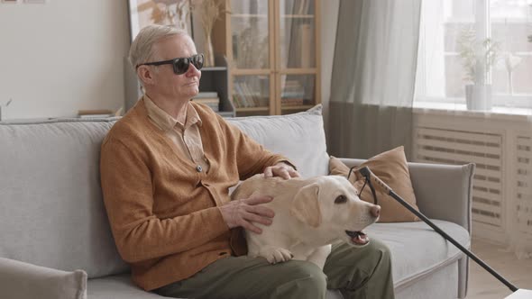 Blind Old Man with Labrador Retriever at Home