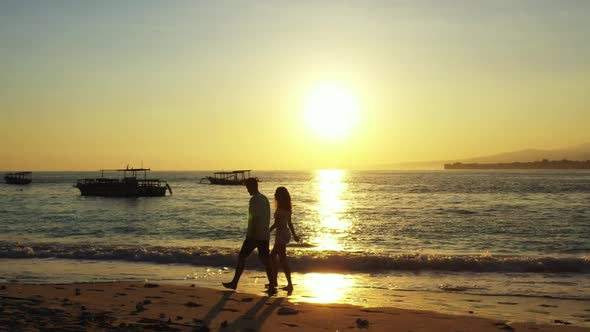 Teenage lovers posing on marine island beach voyage by blue sea with white sand background of Indone