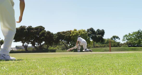 Batsman playing a sweep shot during cricket match