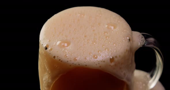 Lager Beer Settles in the Glass with a White Cap of Foam