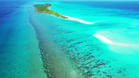 Wide flying island view of a white paradise beach and blue water background in best quality 4K