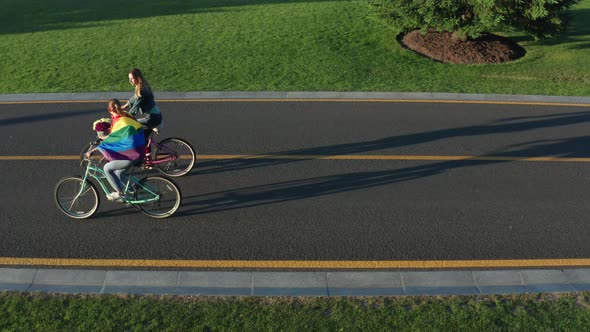 Aerial Side View of Young Lgbt Couple Riding Bikes