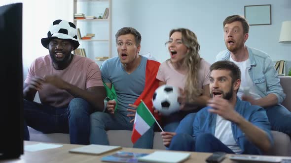 Multiracial Italian Fans Sitting on Sofa and Watching Game, Celebrating Goal