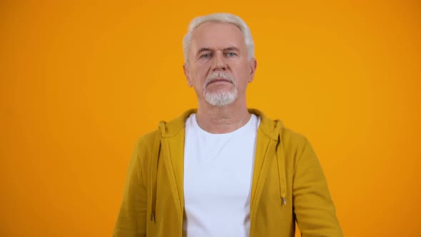 Elderly Male in Casual Clothes Showing Warning Finger Gesture, Rejection Sign