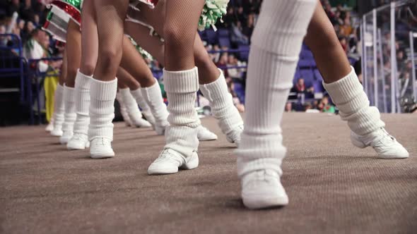 Cheerleaders in White Leg Sleeves Dance Near Hockey Rink