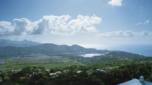 Aerial shot of a city with a dense forest on the mountainous coast of the bay (Saint Lucia)