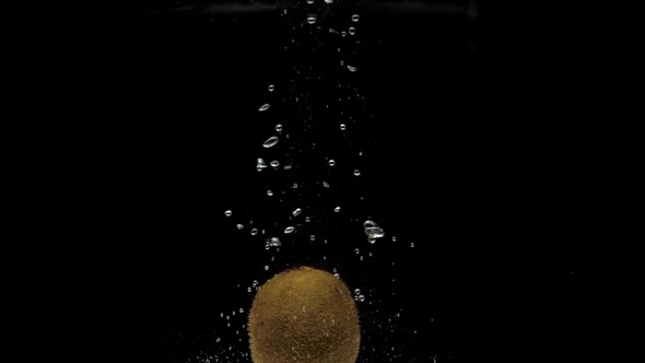 Slow Motion One Kiwi Falling Into Transparent Water on Black Background