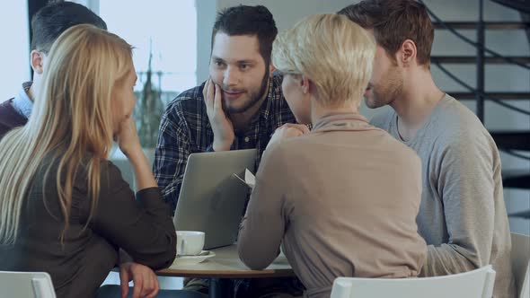 Creative Team of Young Designers Working Together in Their Office During Informal Meeting