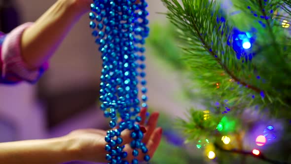 Woman hands decorating christmas tree. Close up view of decorating Christmas tree