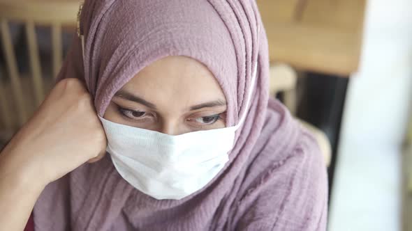 Sad Muslim Women with Face Mask Looking Down