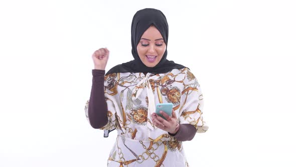 Happy Young African Muslim Woman Using Phone and Getting Good News