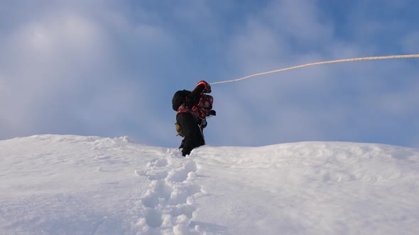 Travelers Descend By Rope From Snowy Hill. Alpinists Team in Winter Down Rope From the Mountain