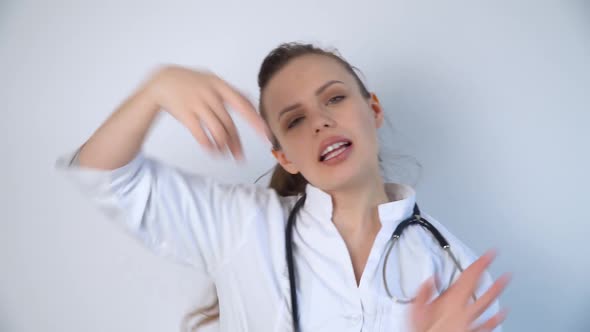 Funny Doctor Woman in a White Coat with a Stethoscope Dancing in a Hospital