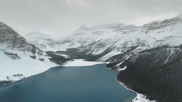 Aerial shot of a frozen Bow Lake and and mountains around it in Alberta, Canada