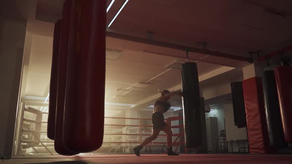 Female Fighter Trains His Punches, Beats a Punching Bag, Training Day in the Boxing Gym