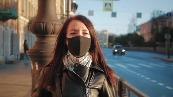 Young Woman in a Medical Mask for Protection From the Epidemic on the Street in the City.