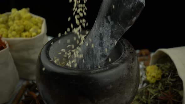 Sesame falling into the granite mortar with pestle