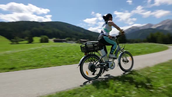 Woman on Electric Eco Bike Cycling Italy Dolomites Alps