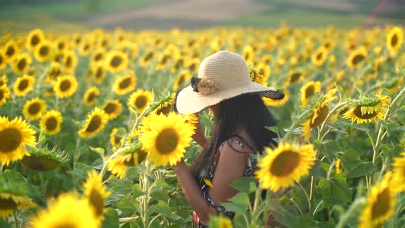 Brunette Girl With Black Hair in a Sunflower Field