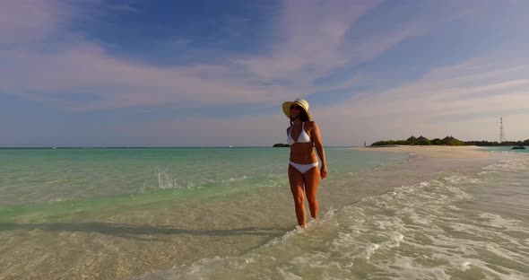 Modern smiling girl on vacation by the sea on beach on summer white sand and blue background 