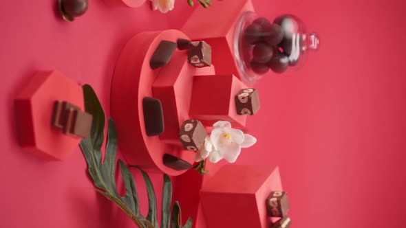 Vertical video, Close up: Composition of chocolate and candies on a red background