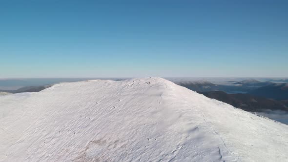 Drone Flying Over Snow Covered Mountain Top