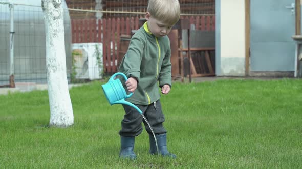 Kid watering the lawn with a watering can