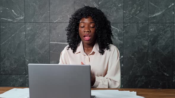 Angry Black Businesswoman with Curly Hair Shouts at Workers