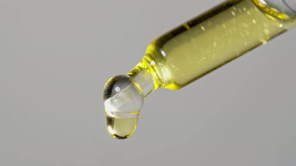 Drops of Oil Extract Dripped From a Glass Pipette for Chemical Reactions and Aromatherapy