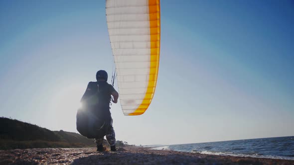 Guy with a paraglider on a sandy beach. Slow Motion