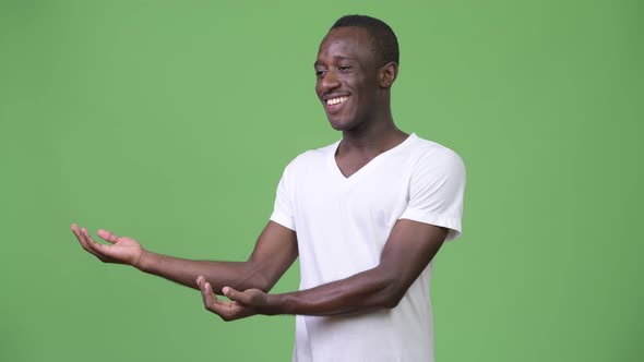 Young African Man Smiling While Showing Something
