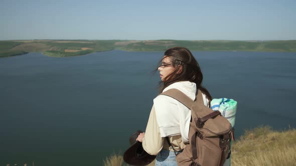 Female Standing on Mountain Peak with Backpack